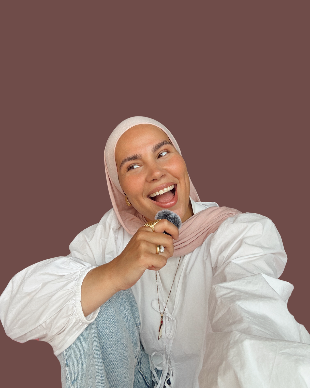 Iman Meskini smiling while holding a microphone