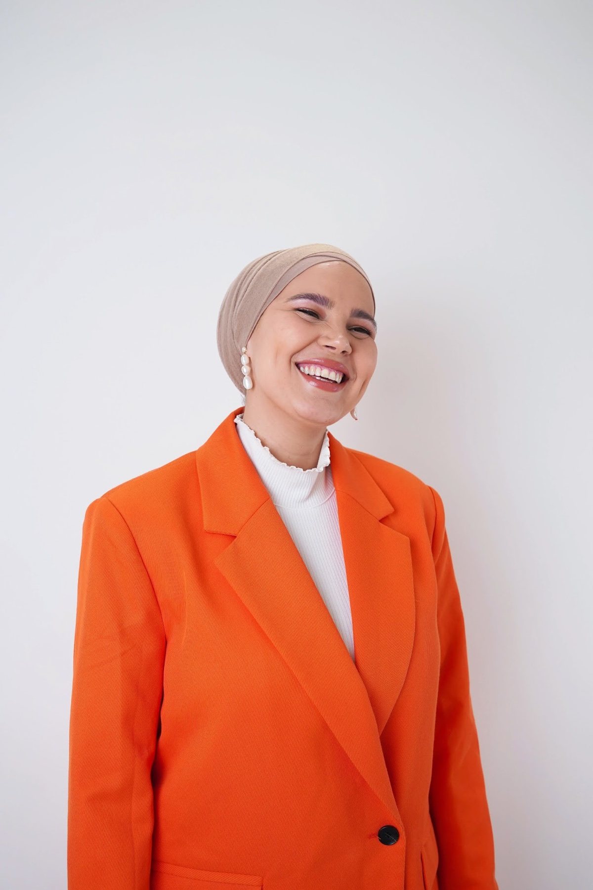 Iman Meskini smiling in an orange blazer